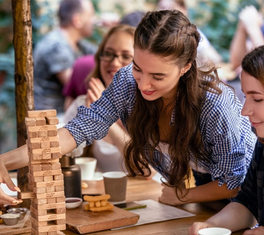 playing-jenga-game-restaurant-with-best-friends-eating-tasty-snacks_8353-10618